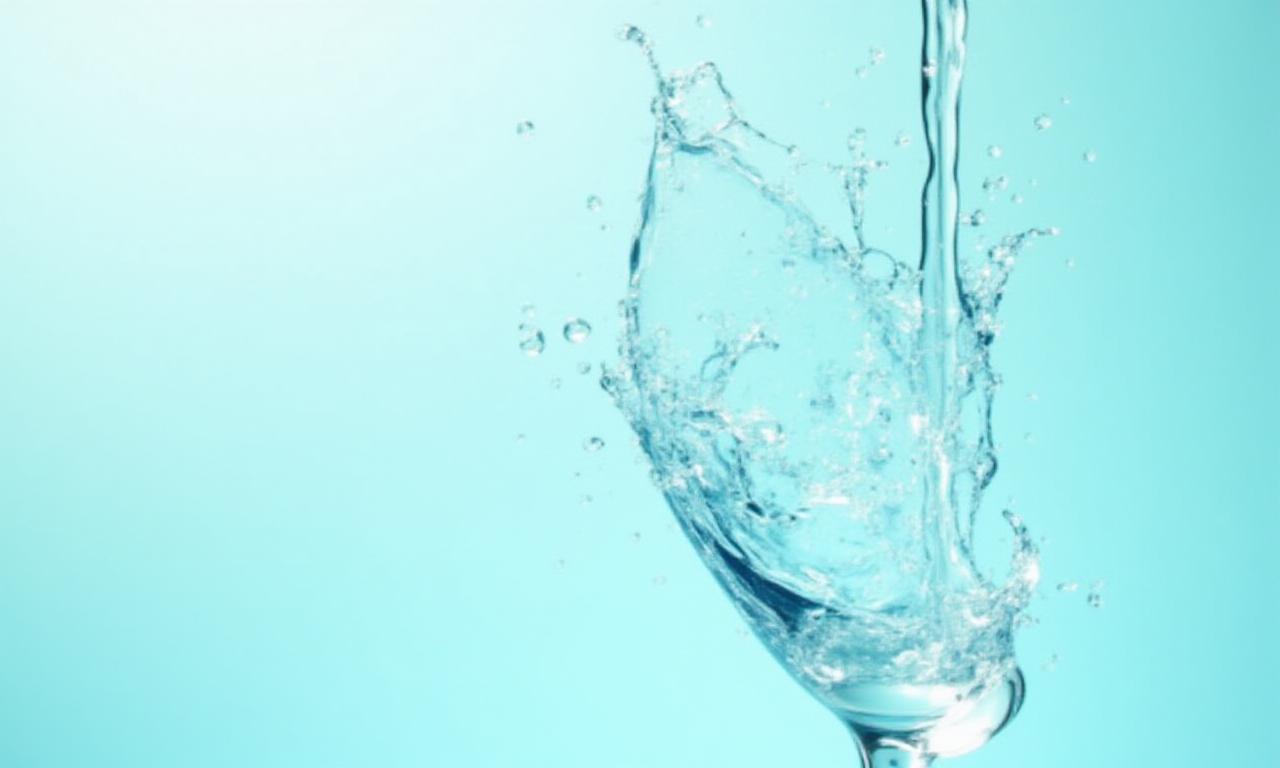 Refreshing splash of mineral water in a clear glass